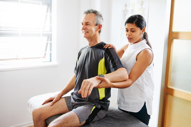 Doctor checking patient shoulder pain