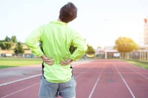 Runner on track grabs lower back in pain