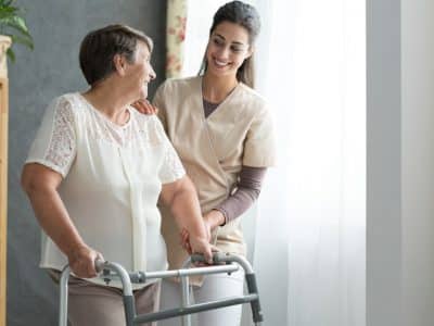 Nurse helping senior to walk