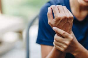 Man holding his hand in discomfort