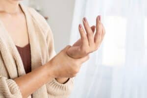 Woman holding her hand experience pain in finger